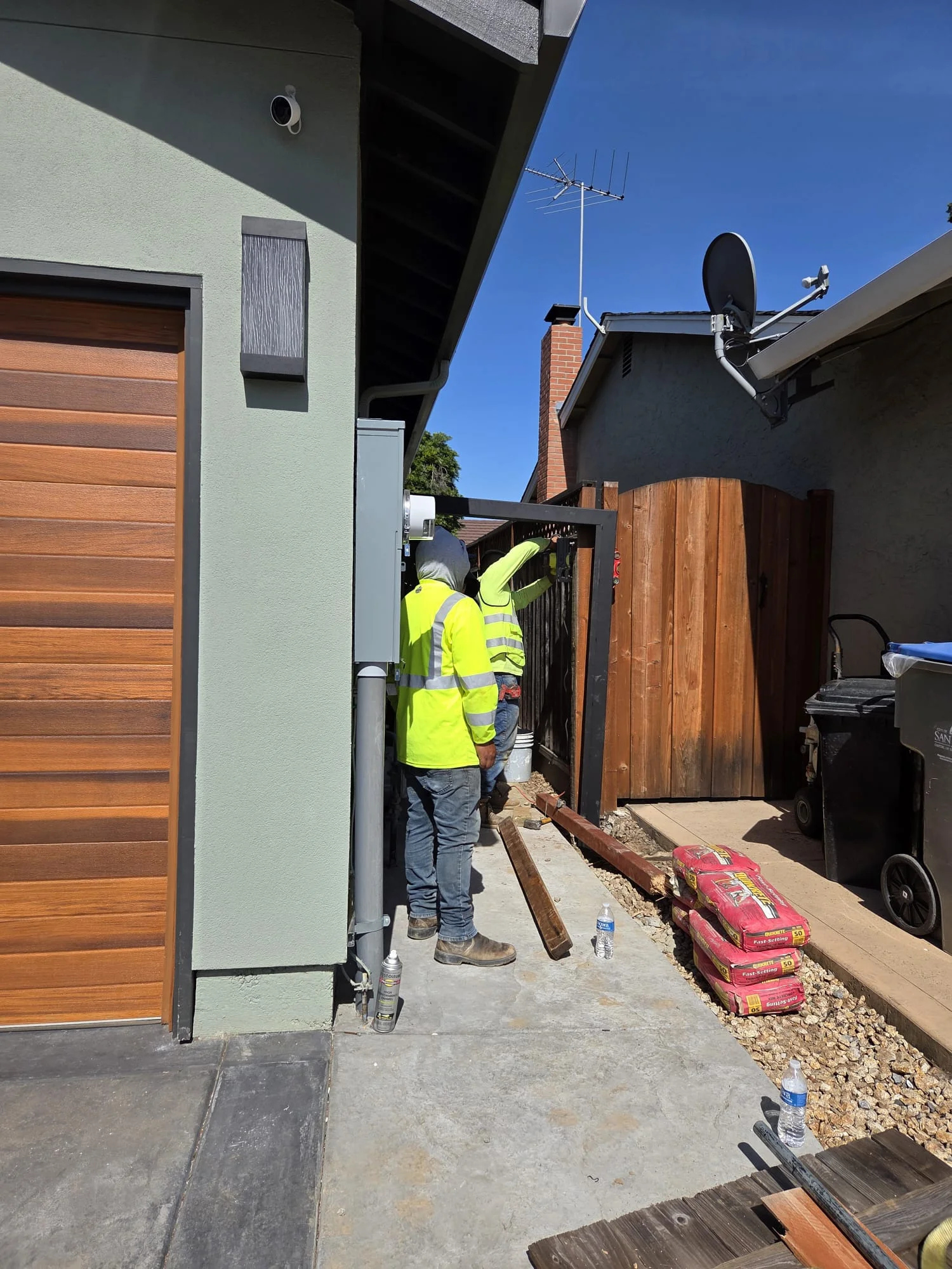 Eagle installer fitting a side gate beside a house