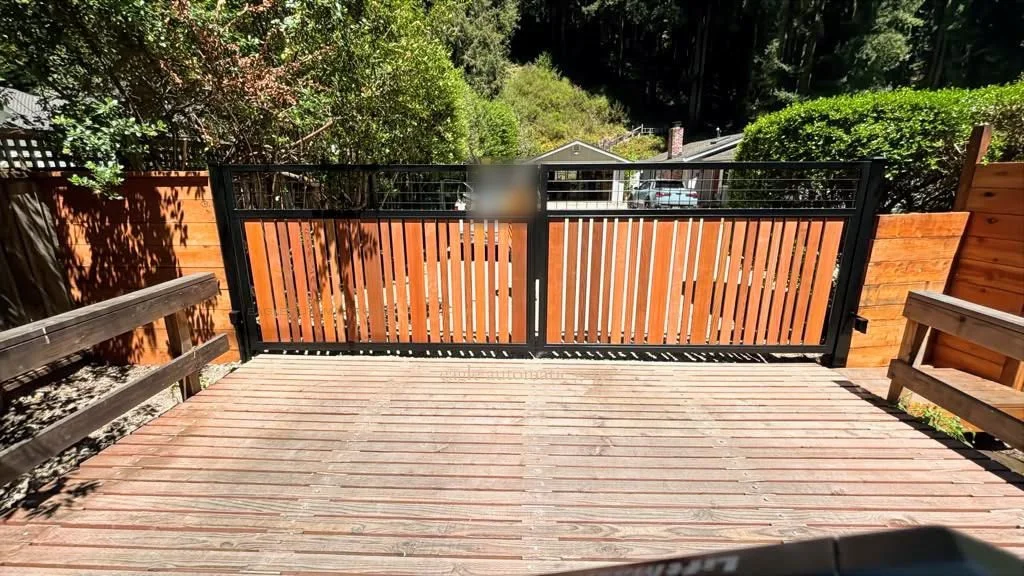 Completed wood-and-steel driveway gates at a timber bridge