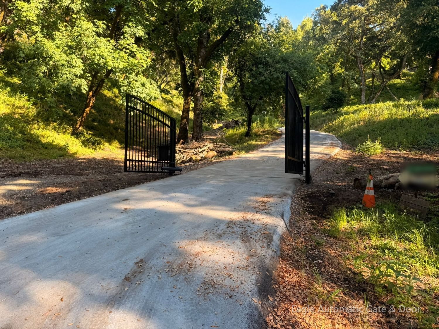 Woodside iron swing gates opened toward the uphill drive